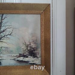 Oil on canvas signed Winter landscape under snowy river edge woods