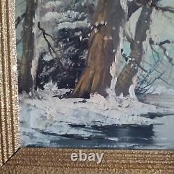 Oil on canvas signed Winter landscape under snowy river edge woods