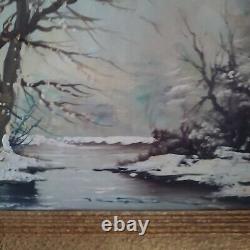 Oil on canvas signed Winter landscape under snowy river edge woods