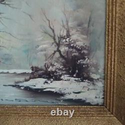Oil on canvas signed Winter landscape under snowy river edge woods