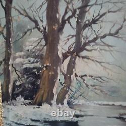 Oil on canvas signed Winter landscape under snowy river edge woods