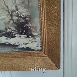 Oil on canvas signed Winter landscape under snowy river edge woods
